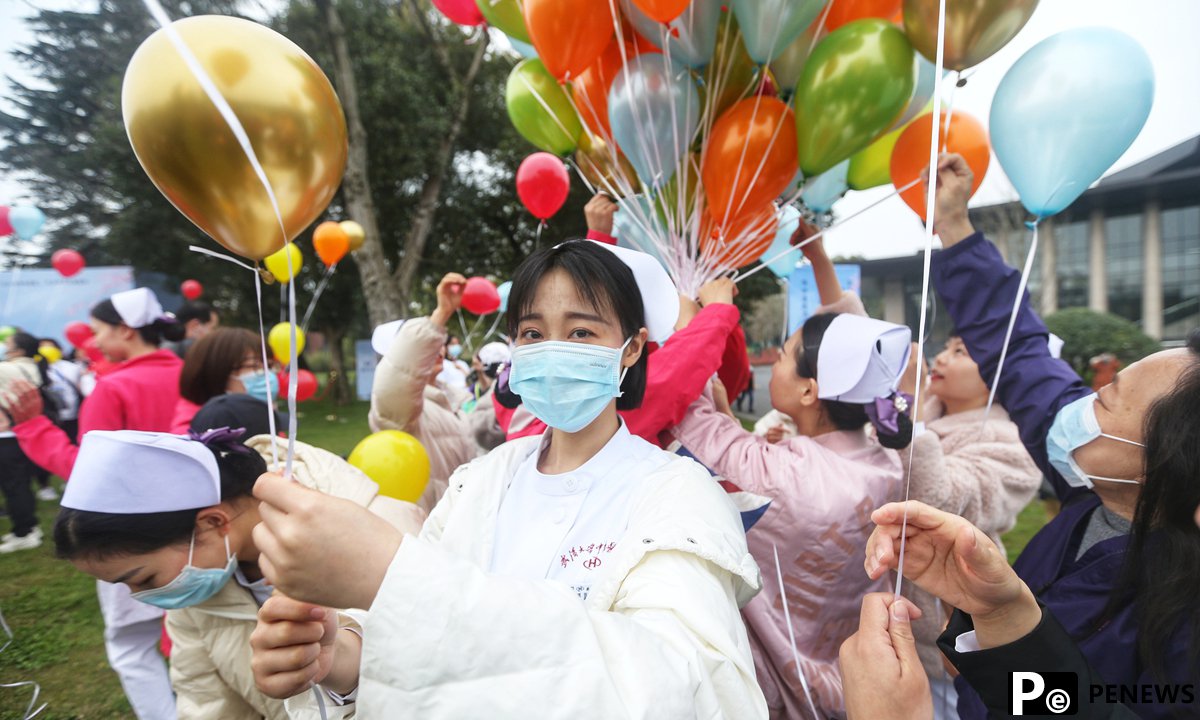 One year after outbreak, medics from around the country return to Wuhan to enjoy cherry blossoms