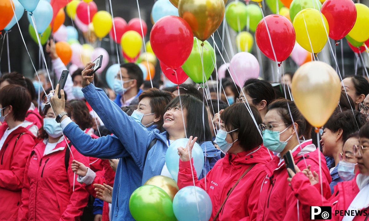 One year after outbreak, medics from around the country return to Wuhan to enjoy cherry blossoms