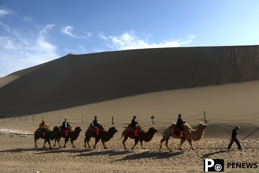 Tourists enjoy picturesque spring views of desert in Dunhuang, NW China