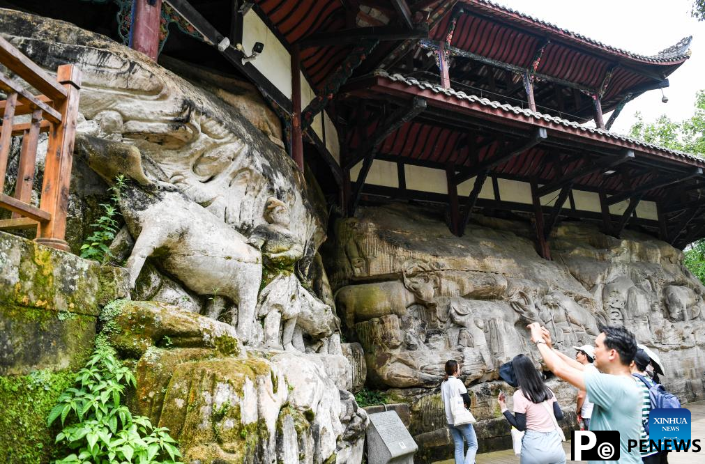 Tourists visit scenic spot of Dazu Rock Carvings in China