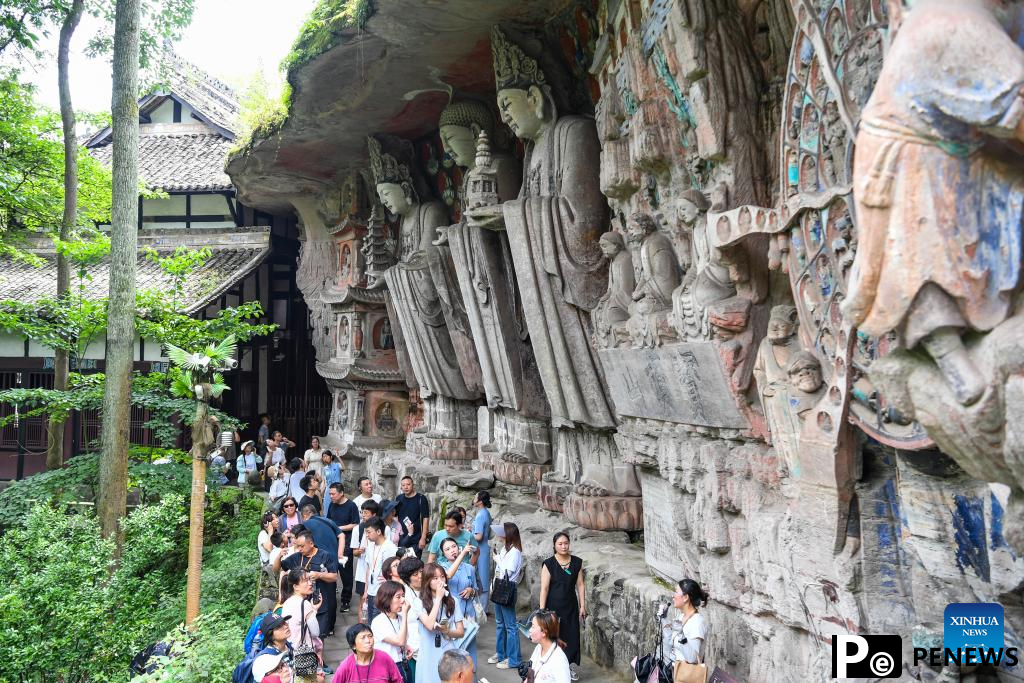 Tourists visit scenic spot of Dazu Rock Carvings in China