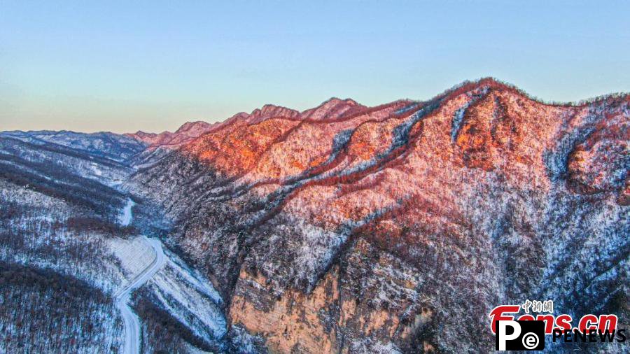 Morning glow adds color to snowy mountain at Shennongjia