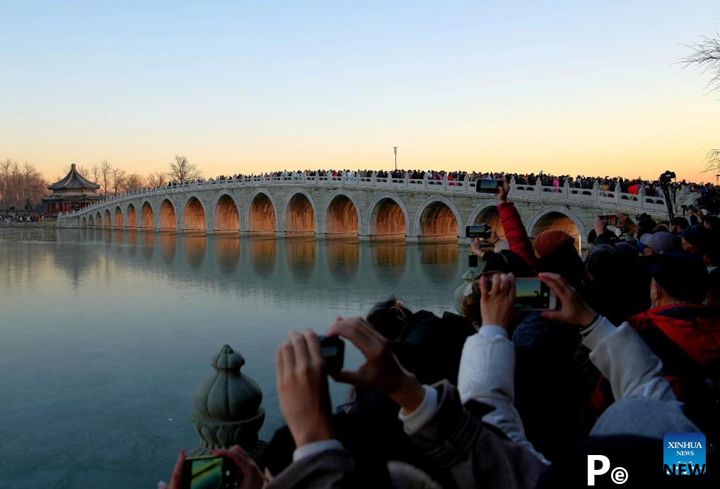 People visit 17-Arch Bridge in Summer Palace, China