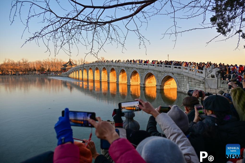 People visit 17-Arch Bridge in Summer Palace, China