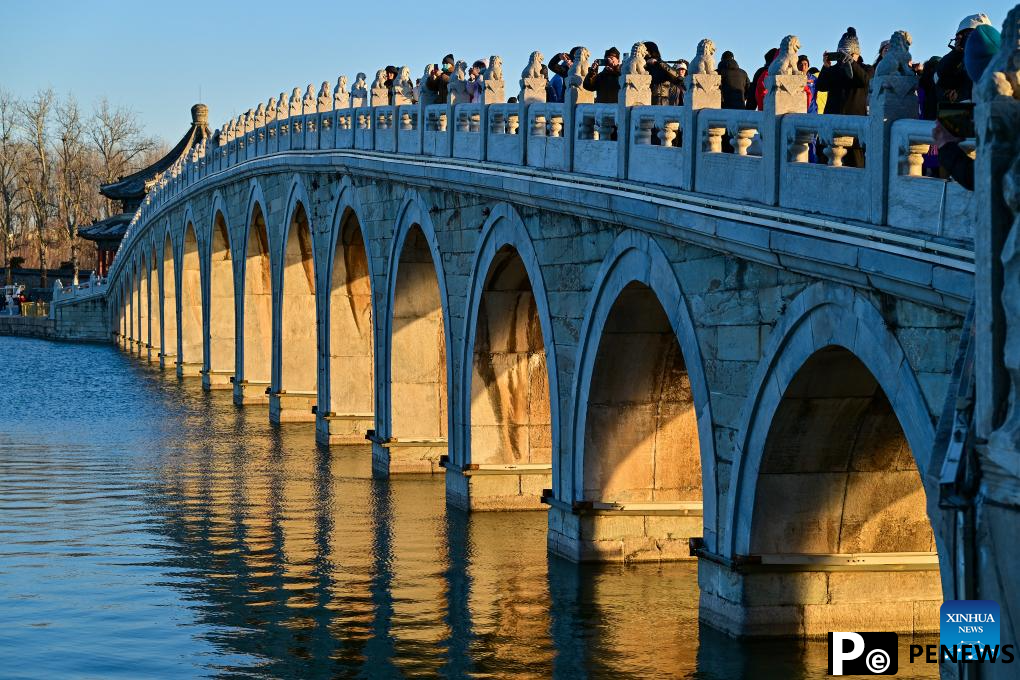 People visit 17-Arch Bridge in Summer Palace, China
