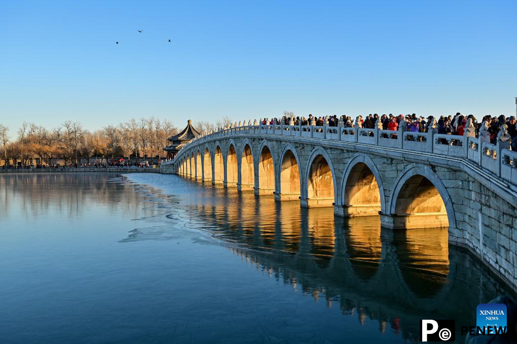 People visit 17-Arch Bridge in Summer Palace, China