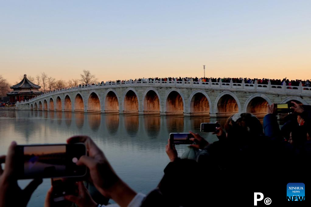 People visit 17-Arch Bridge in Summer Palace, China
