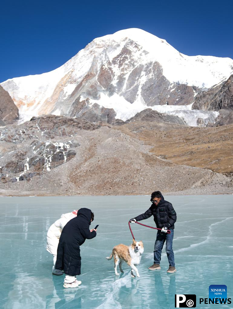 Tourists have fun on icy lake in Lhasa, China