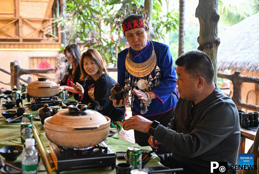 Tourists enjoy traditional family reunion dinner of Li ethnic group in China
