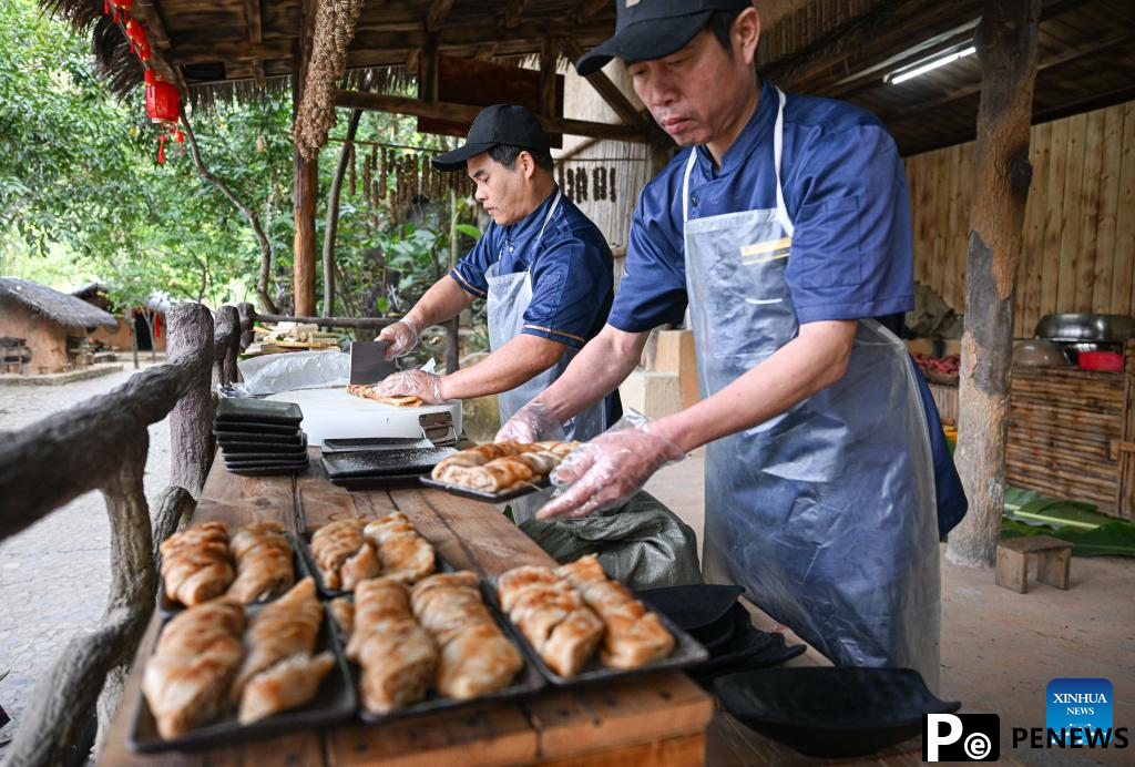 Tourists enjoy traditional family reunion dinner of Li ethnic group in China