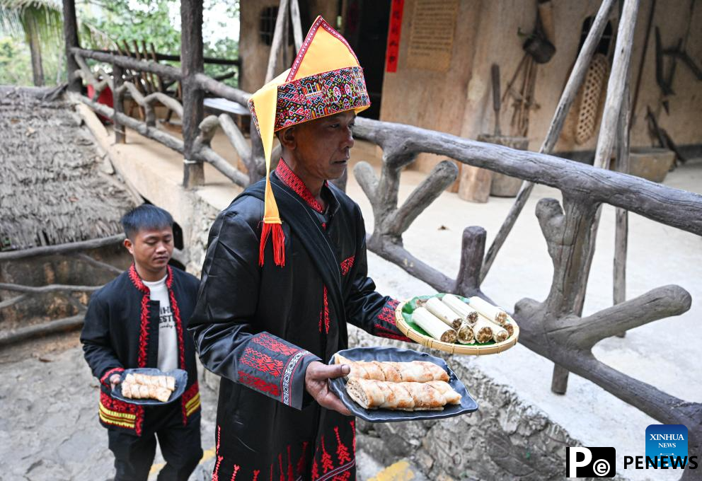Tourists enjoy traditional family reunion dinner of Li ethnic group in China