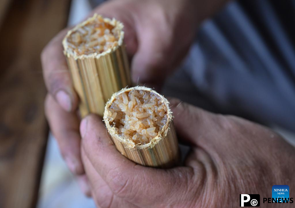 Tourists enjoy traditional family reunion dinner of Li ethnic group in China