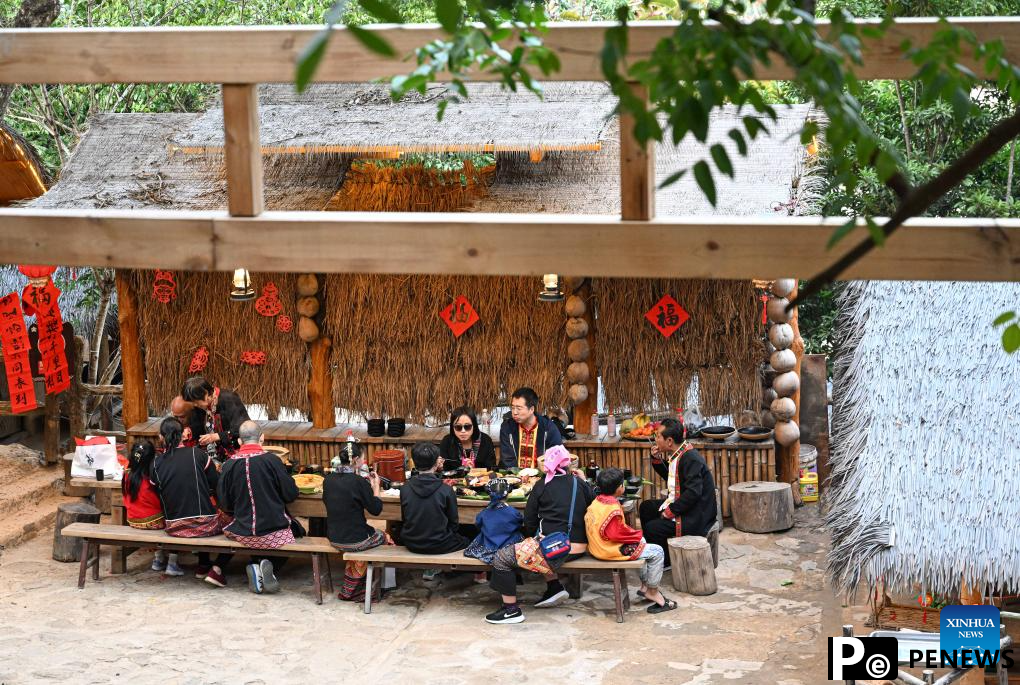Tourists enjoy traditional family reunion dinner of Li ethnic group in China