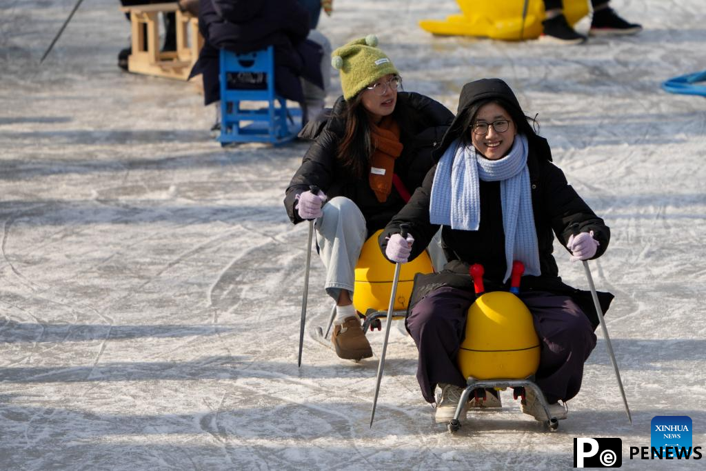 People have fun on ice rink at Tuanjiehu Park in Beijing