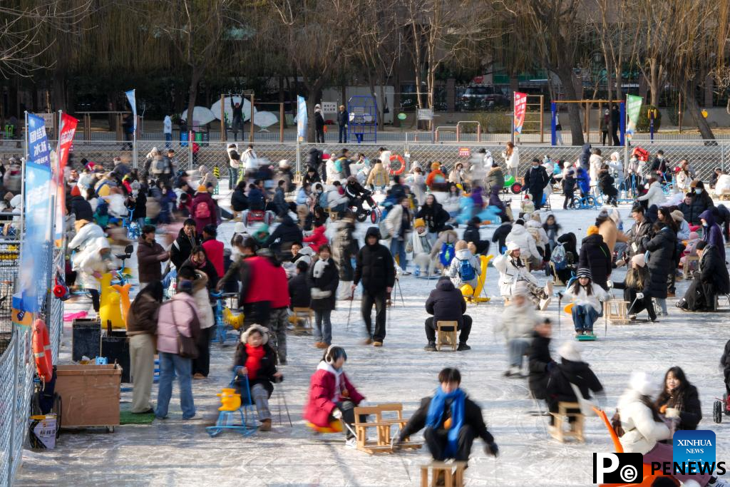 People have fun on ice rink at Tuanjiehu Park in Beijing