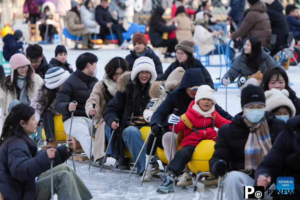 People have fun on ice rink at Tuanjiehu Park in Beijing
