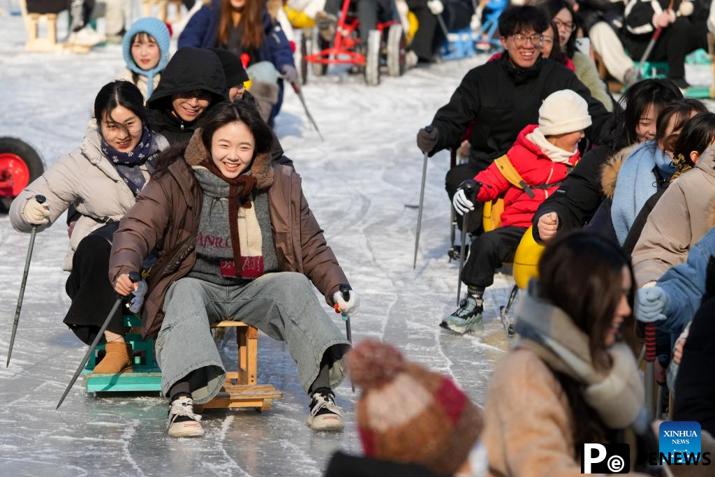 People have fun on ice rink at Tuanjiehu Park in Beijing