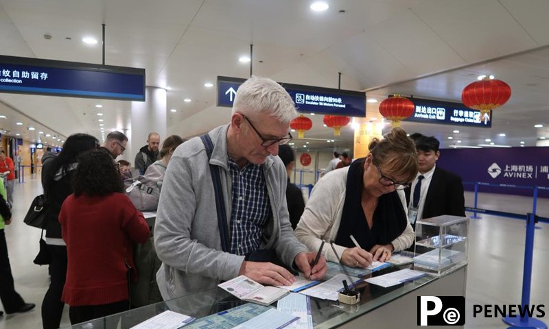 Foreign tourists fill out entry registration cards at the Shanghai Pudong International Airport in Shanghai, east China, Jan. 26, 2025. (Xinhua/Tang Siqi)