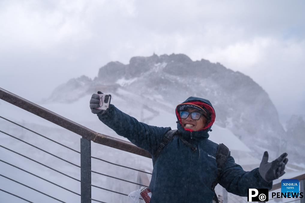 Picturesque snowy scene on snow mountain attracts tourists in SW China