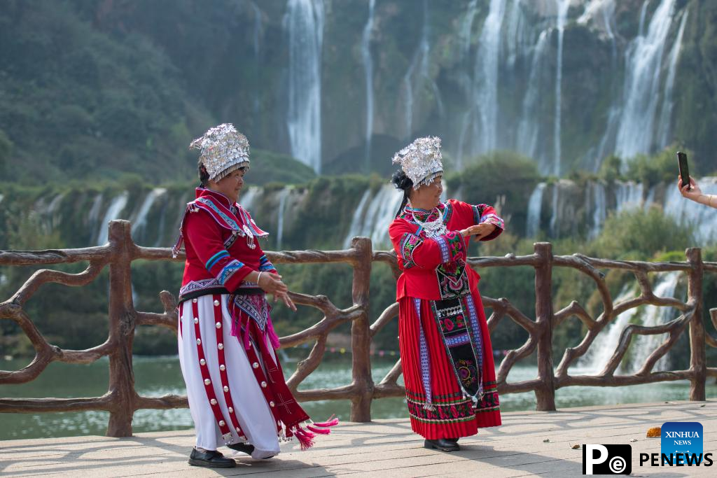 Tourists have fun at scenic area of Jiulong Waterfalls in SW China