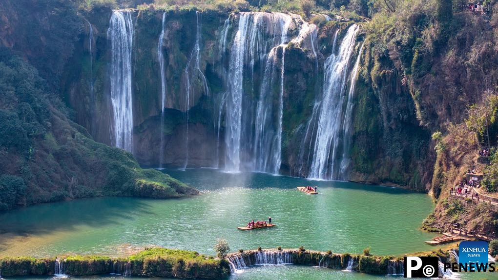 Tourists have fun at scenic area of Jiulong Waterfalls in SW China