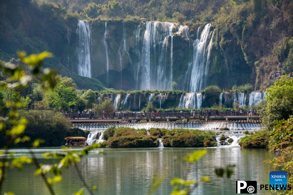 Tourists have fun at scenic area of Jiulong Waterfalls in SW China