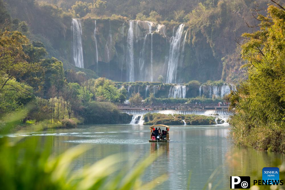 Tourists have fun at scenic area of Jiulong Waterfalls in SW China