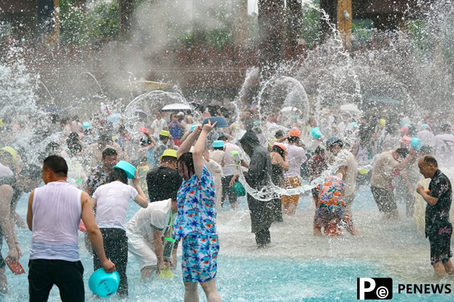 Tourists enjoy splashing water in Xishuangbanna, SW China
