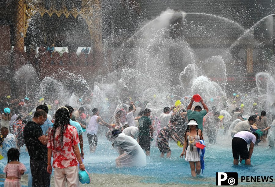 Tourists enjoy splashing water in Xishuangbanna, SW China