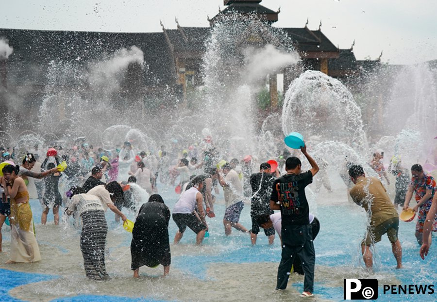 Tourists enjoy splashing water in Xishuangbanna, SW China