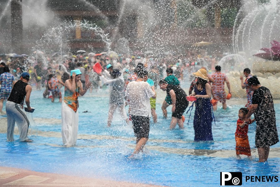 Tourists enjoy splashing water in Xishuangbanna, SW China
