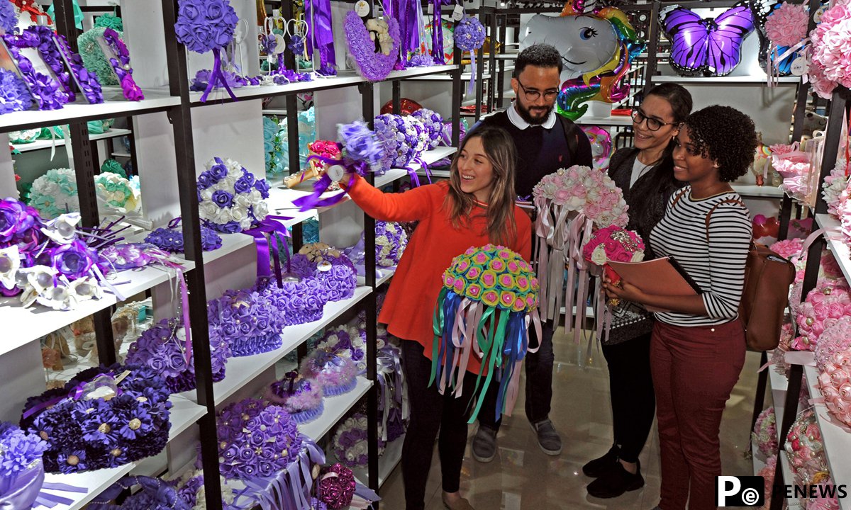 A merchant (L) from Colombia introduces wedding decorations to purchasers in Yiwu, east China's Zhejiang Province, Oct. 22, 2018. (Photo:Xinhua)